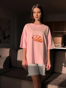 Λεπτομέρεια από ροζ βαμβακερό T-shirt με χαριτωμένο σχέδιο κρουασάν και φιόγκο