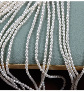 Macro detail of high-luster 2.5mm natural freshwater seed pearls on green velvet
