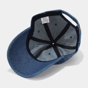 Detail of internal sweatband and 100% cotton wash label on washed denim baseball cap