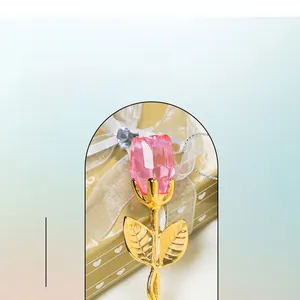 Detail of pink crystal rose bud with golden stem and leaves in a heart shaped gift box