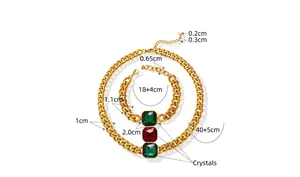 Detailed view of gold Cuban chain jewelry set with green and red crystals and dimensions