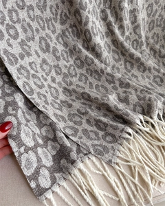 Macro view showing the soft leopard pattern fabric and fringe details of this brown shawl