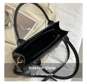 Detailed top view showing internal three-compartment structure of black handbag