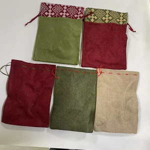 Détail de cinq sacs cadeaux en lin avec bordures à motifs géométriques colorés