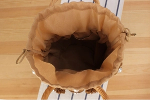 Top view of handmade bucket bag interior showing khaki drawstring lining and pearl detail