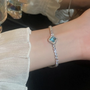 Detailed view of flower bracelet with aqua and white cubic zirconia on wrist