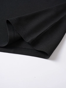 Close-up of black men's polo shirt showing premium knit fabric texture and hem stitching