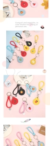 Close-up of cute cartoon fruit keychains with woven leather straps and metal rings