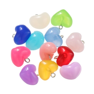 Macro shot of colorful heart-shaped acrylic pendants with metal rings for jewelry making