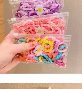 Détail d'élastiques à cheveux en maille colorée dans un sac à motif marguerites