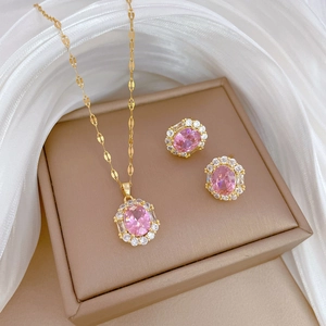 Elegant gold titanium steel jewelry set featuring pink zircon necklace and earrings on silk