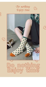 Detail of argyle knit mid-calf socks in orange, green and beige patchwork cotton