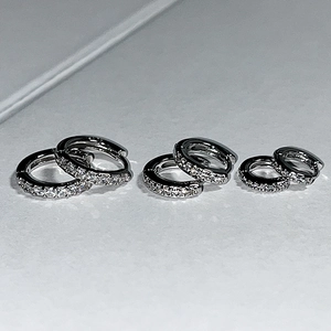 Detailed comparison of three different sizes of silver hoop earrings with pavé zircons