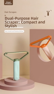 Close-up of portable T-shape lint remover in mint green and orange on a pink stand