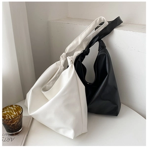 Detail of matte faux leather tote bag showing knotted shoulder strap and large capacity