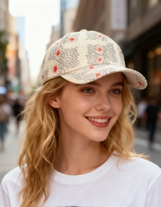Close-up of cream baseball cap featuring black crackle print and red star embroidery