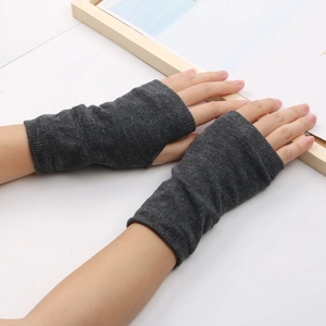 Gros plan de mitaines en tricot gris foncé portées sur les mains sur fond blanc pur
