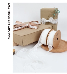 Detailed view of white floral lace ribbon roll for elegant wedding gift wrapping