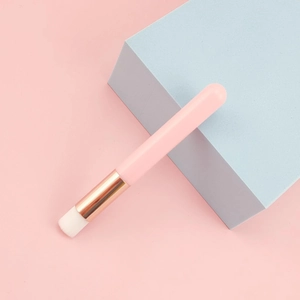 Detail of soft white bristles and pink handle on a professional lash cleaning brush