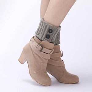 Detail of cable knit leg warmers with buttons paired with beige suede chunky heel boots