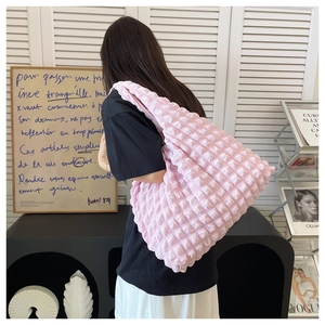 Detail of a large pink shoulder tote bag with a unique textured puff bubble fabric