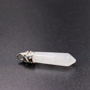 Detailopname van witte zeshoekige kristallen hanger met sierlijke zilveren metalen sluiting