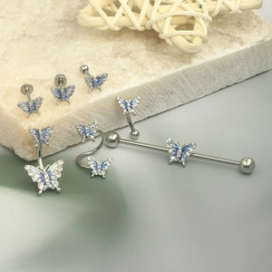 Macro detail of silver butterfly body jewelry set with blue enamel and crystal inlays