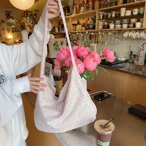 Detailed texture of floral canvas tote bag with pink flower pattern and wide shoulder strap