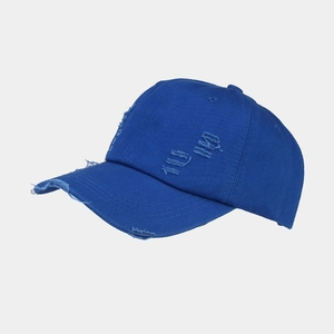Close-up of distressed denim baseball cap detailing wash worn holes and cotton fabric texture