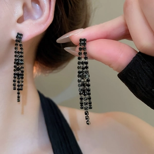 Gros plan détaillé de boucles d'oreilles à pompons en zircon noir pour parure mariée