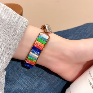 Détail macro de pierres arc-en-ciel avec bracelet en cuir tressé et fermoir en métal vintage