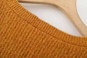 Detail of mustard yellow knit sweater with ribbed neckline and soft mohair texture