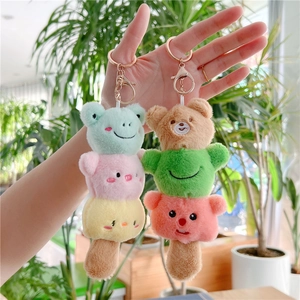 Close-up of colorful plush toy keychains featuring stacked animal heads held in hand