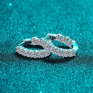 Sparkling S925 sterling silver hoop earrings with moissanite stones on blue glitter background