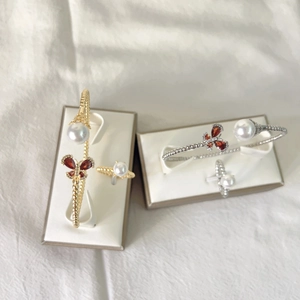 Detailed shot of gold and silver butterfly jewelry sets with pearls and red stones