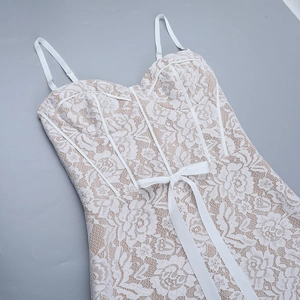 Close-up of white floral lace embroidery on corset dress with a satin bow detail