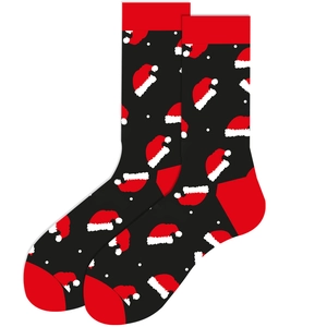 Close-up of black Christmas socks with red santa hat patterns and white polka dots