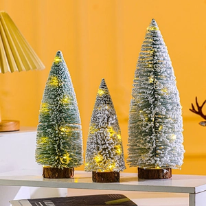 Trio of flocked mini Christmas trees with warm LED lights and rustic wooden bases