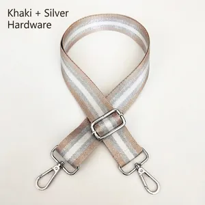 Close-up of khaki and silver striped nylon bag strap with metal hooks and buckle