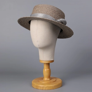 Detailed macro view of woven raffia texture and gray silk ribbon bow on flat top boater hat