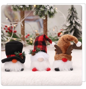 Close-up of three plush Christmas gnomes with glowing LED lights for holiday tree decor