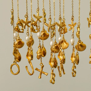 Detail of 18k gold plated starfish and freshwater pearl initial letter necklaces