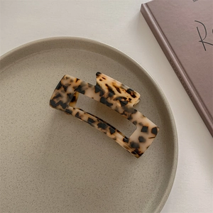 French vintage leopard print acetate claw clip displayed on a minimalist ceramic plate