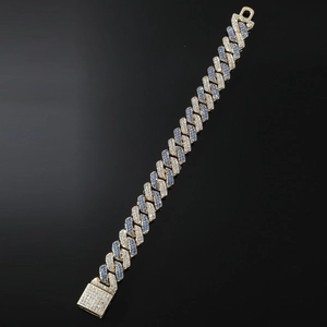 Detail of gold Cuban chain bracelet with alternating white and blue pavé crystals