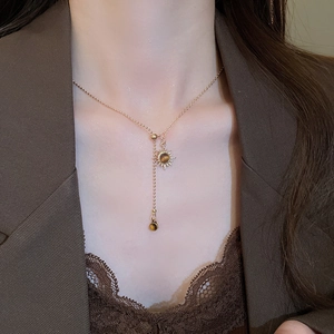 Détail du collier pendentif tournesol en œil de tigre avec chaîne dorée sur mannequin