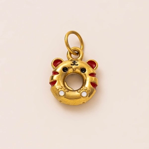 Gros plan d'un pendentif donut tigre plaqué or 18K avec rayures rouges et gravure Roi