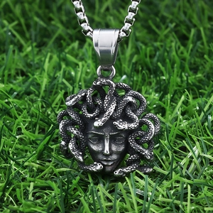 Detailed macro view of vintage stainless steel Medusa pendant with textured snake hair