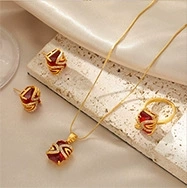 Detailed macro view of 14k gold-plated jewelry set with square red gems on marble