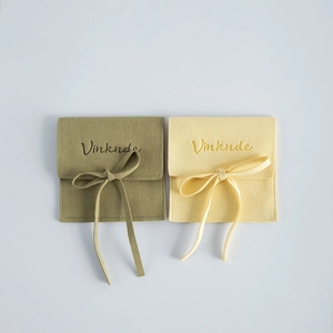 Square microfiber suede jewelry pouches in olive and cream with ribbons.