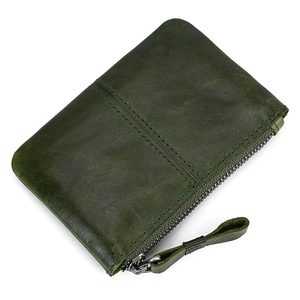 Close-up of a dark green leather coin purse with zipper closure and smooth leather texture